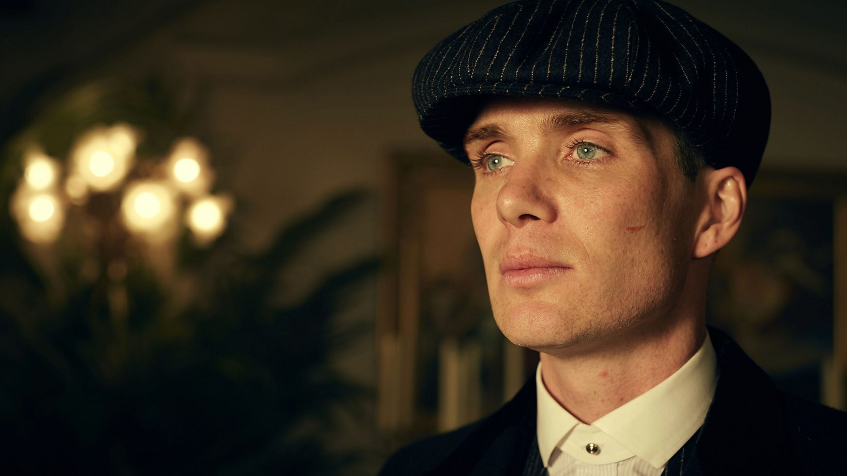 Cillian Murphy in character as Tommy Shelby, wearing the iconic hat and dressed in smart clothing