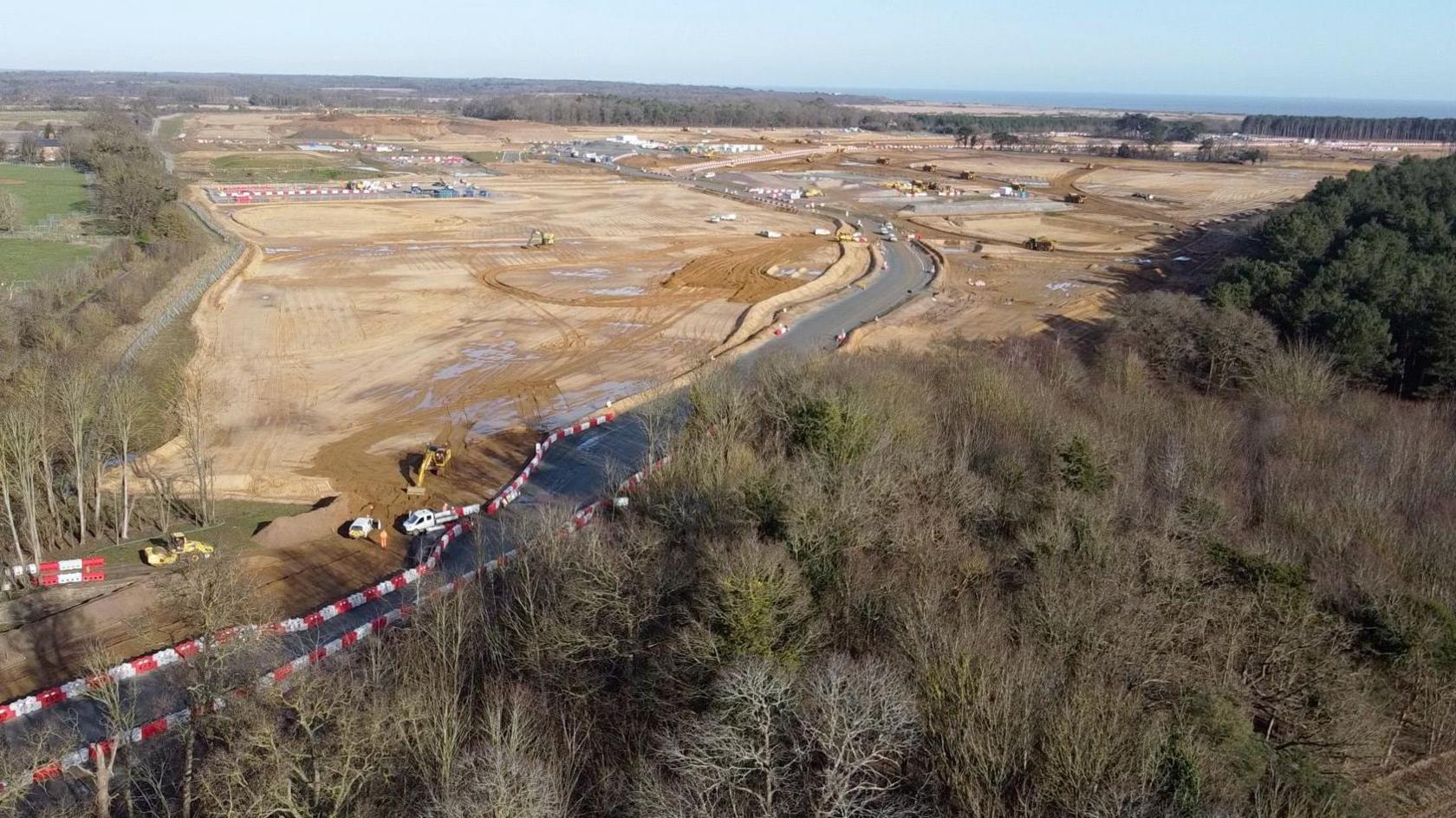 New road and large area with diggers and earthmoving equipment