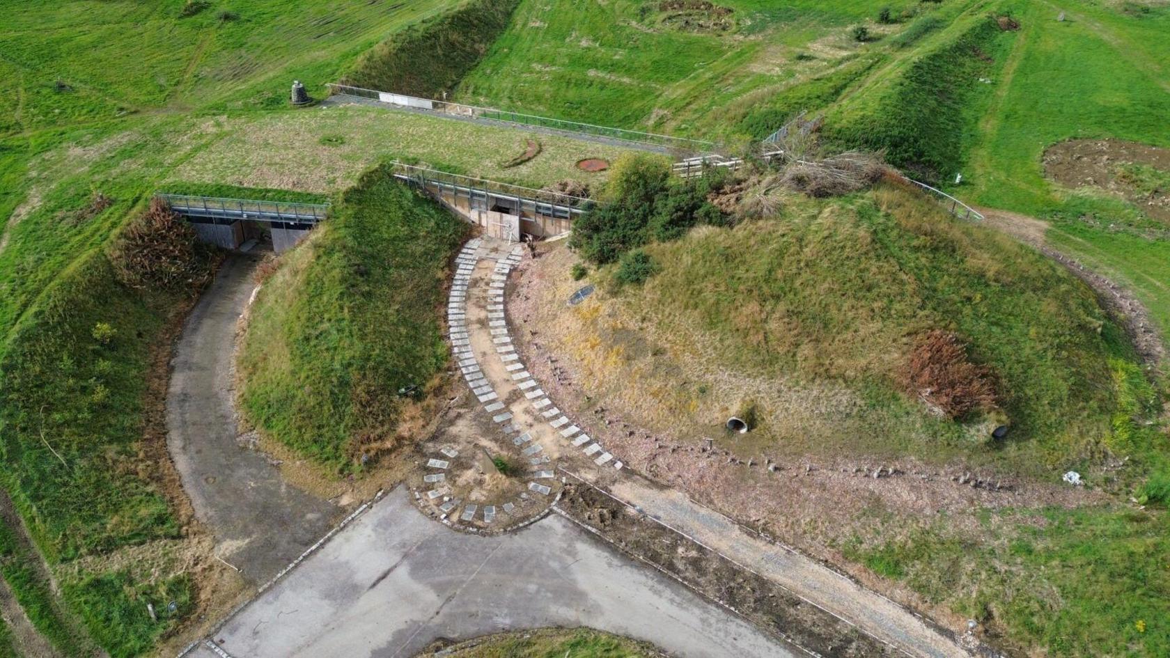 An aerial view of Archaeolink Prehistory Park. The building has a grass roof and blends into the rural landscape. 