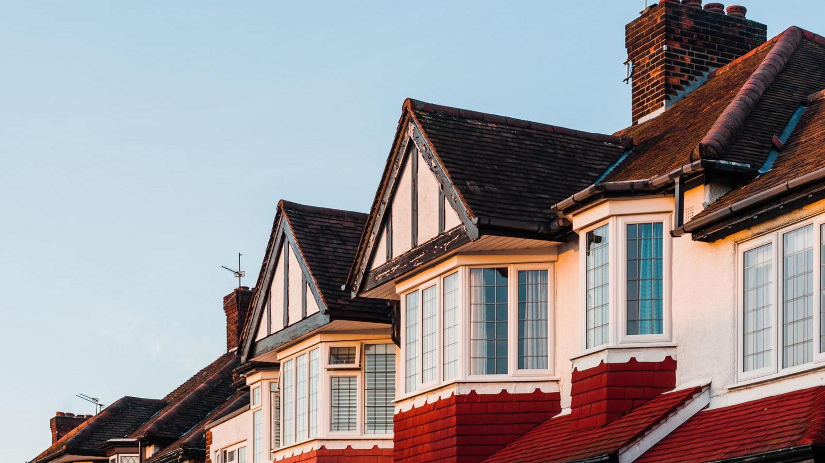 The roofs of houses visible in a photo on a clear blue day