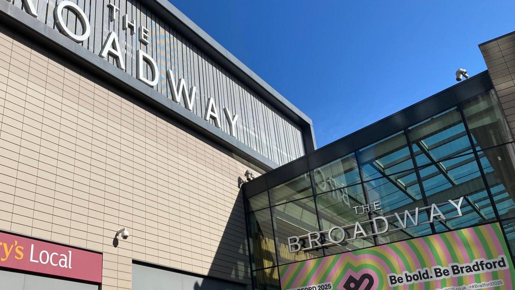 Two signs outside a shopping centre reading The Broadway