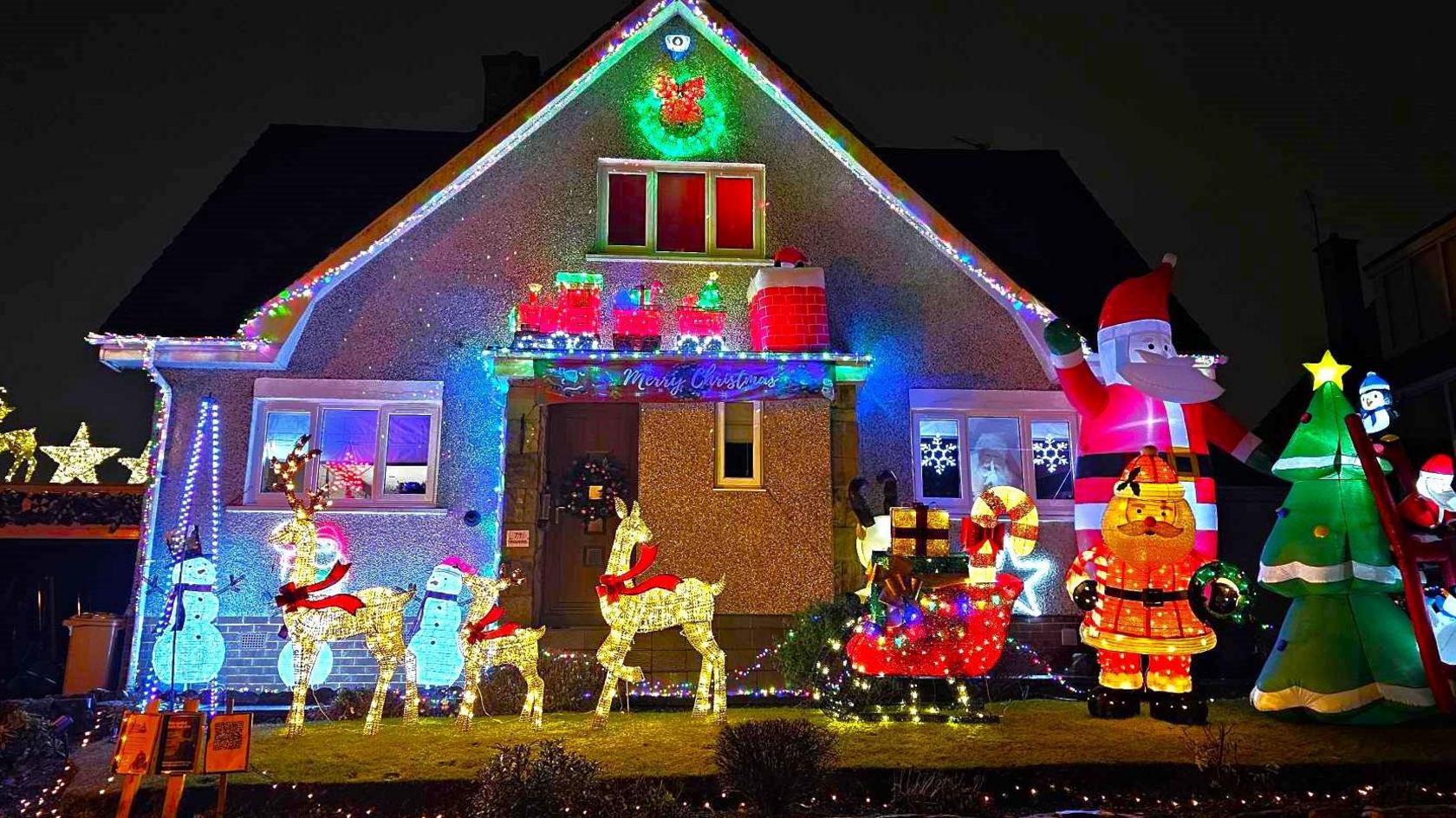 Home covered in christmas lights and inflatables 