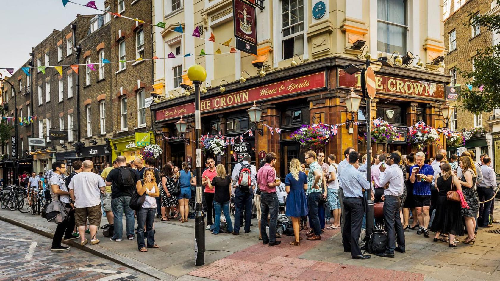 People standing outside a pub named The Crown