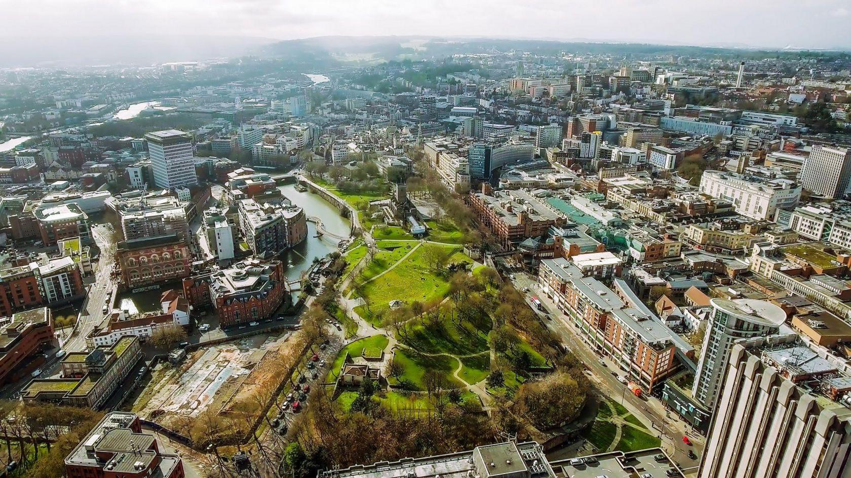 An aerial view of Bristol city centre showing Castle Park and Cabot Circus in the foreground and the Floating Harbour in the distance