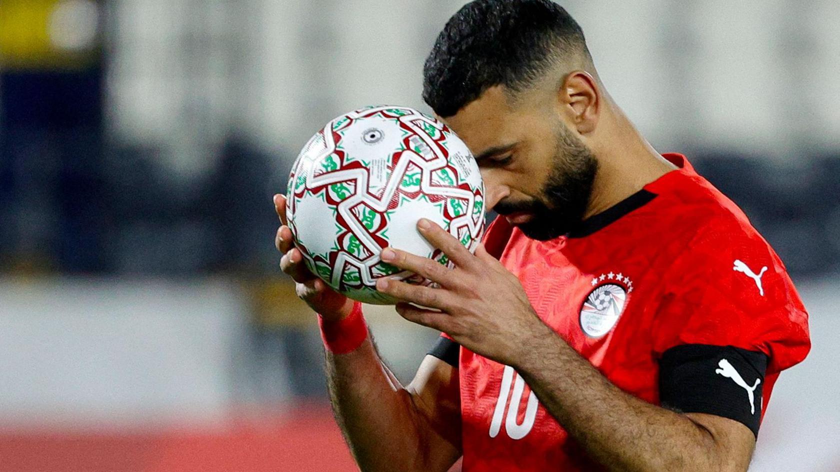 Mohamed Salah holds his head down to a football