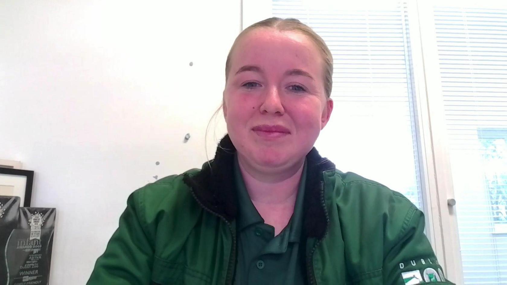 Diana Farrell. She has brown hair tied back, wearing a green polo shirt with green Dublin Zoo jacket.