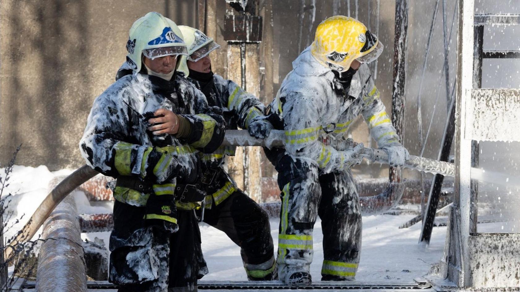 Firefighters work at the site of a critical infrastructure facility hit by a Russian missile strike