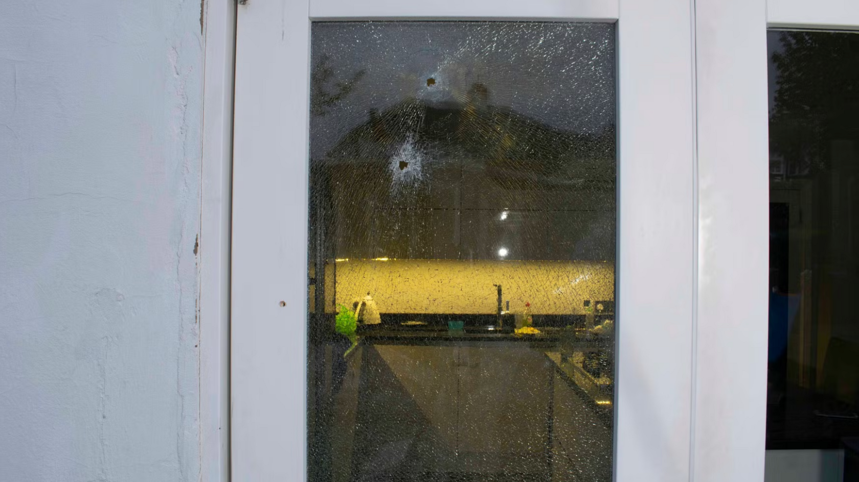 Two bullets tore through the glass of a conservatory and hit Paul Allen as he stood inside his kitchen. A kitchen light can be seen on in the distance