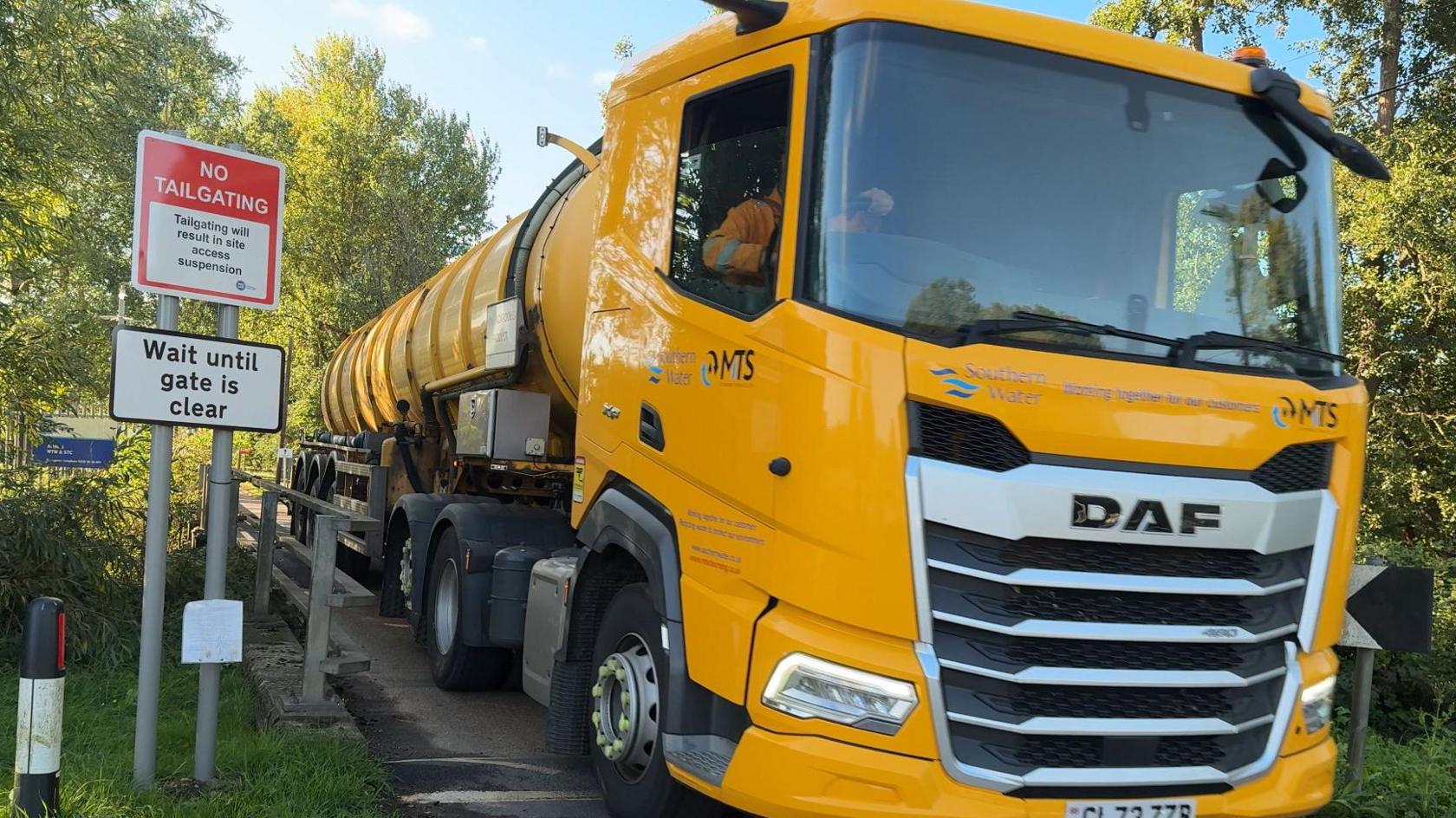 Yellow sewage tanker lorry exiting the gates of Ashford Water Treatment Works.