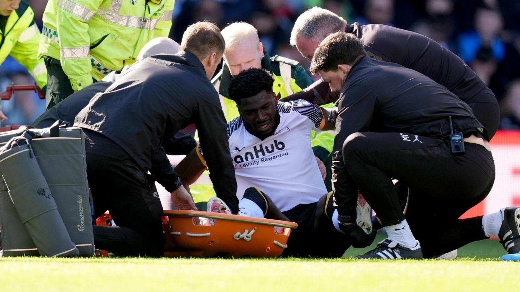 Derby County and United States striker Patrick Agyemang receives treatment after being injured against Stoke