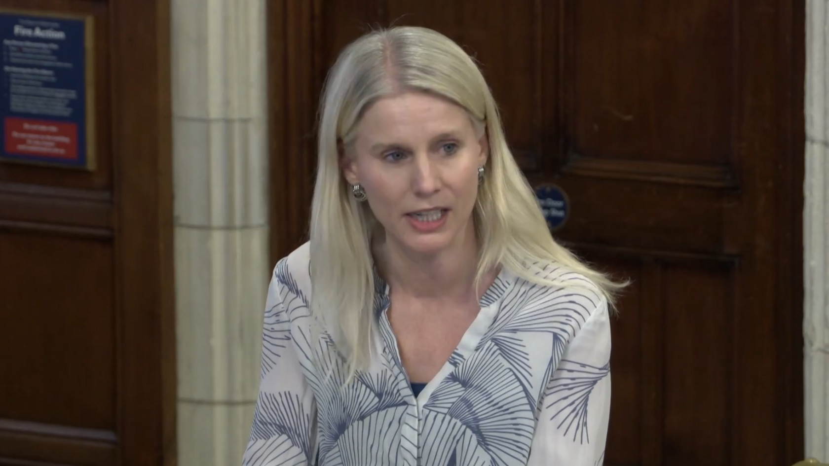 Rebecca Paul, the Reigate MP, talking in a debate at Westminster Hall in Parliament. She is wearing a white top with a blue pattern. 