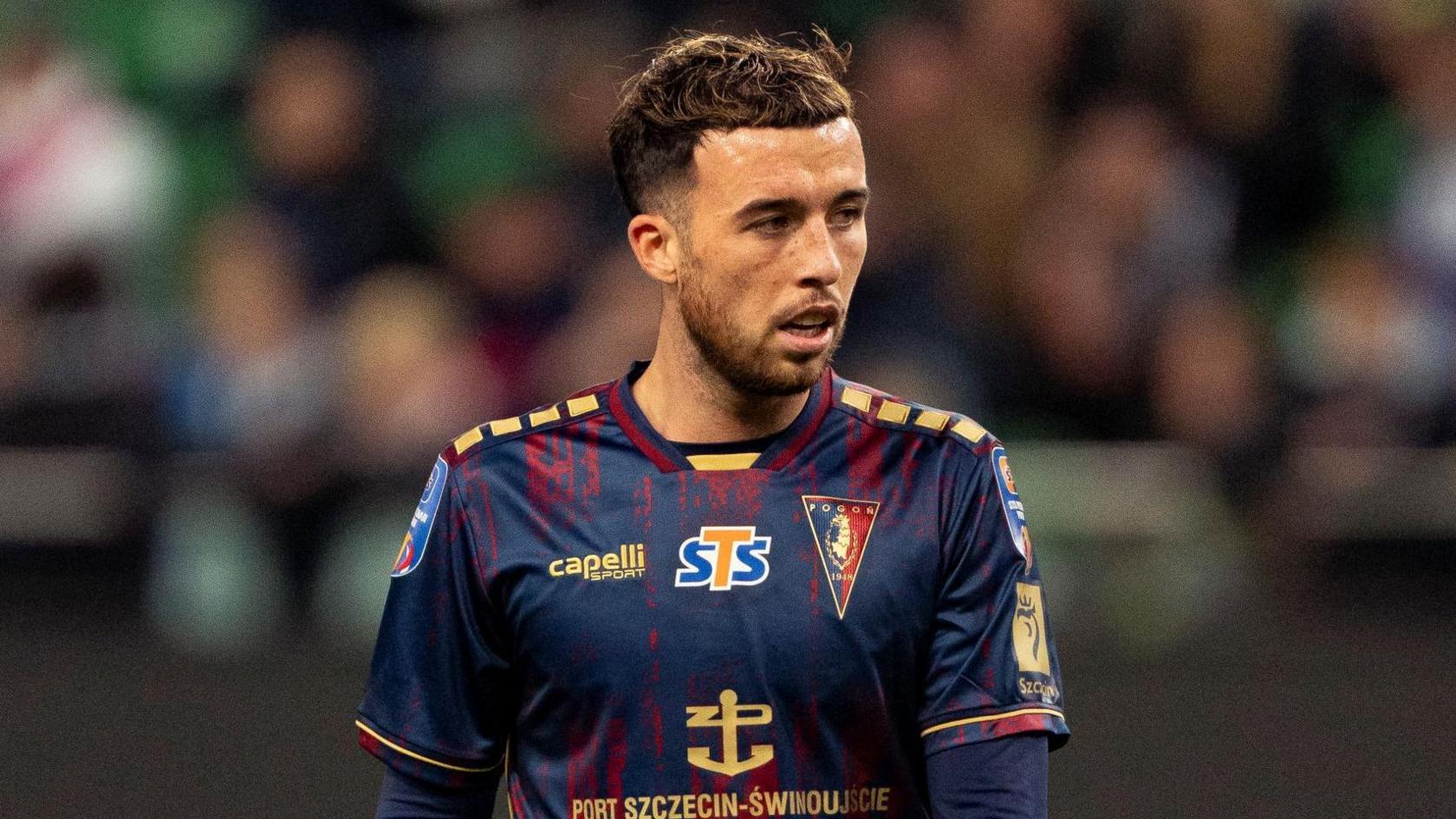Sam Greenwood standing on the pitch during a match for Pogon Szczecin