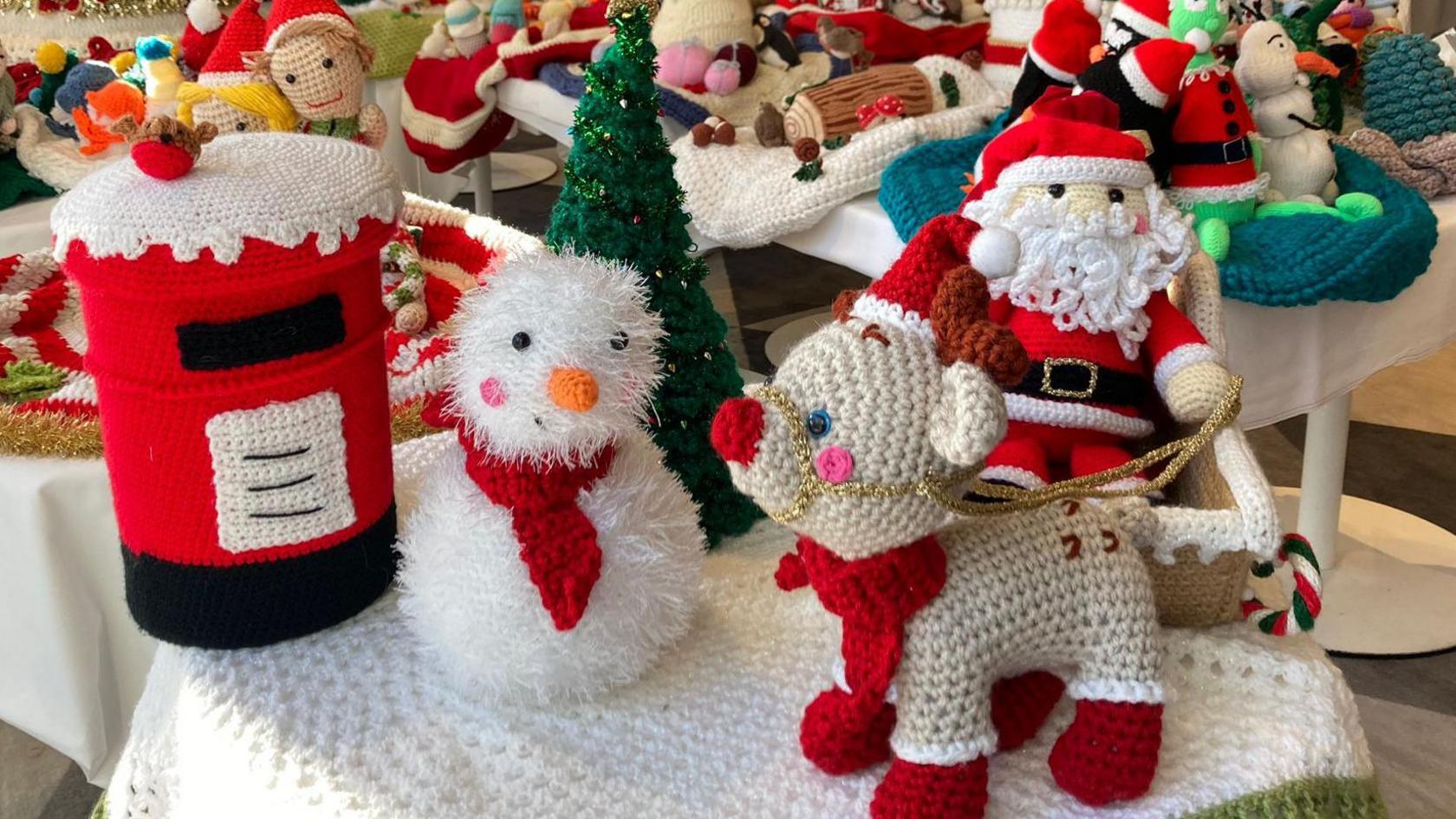 Colourful knitted Santa Claus, reindeer, snowmen, cakes and Christmas trees.