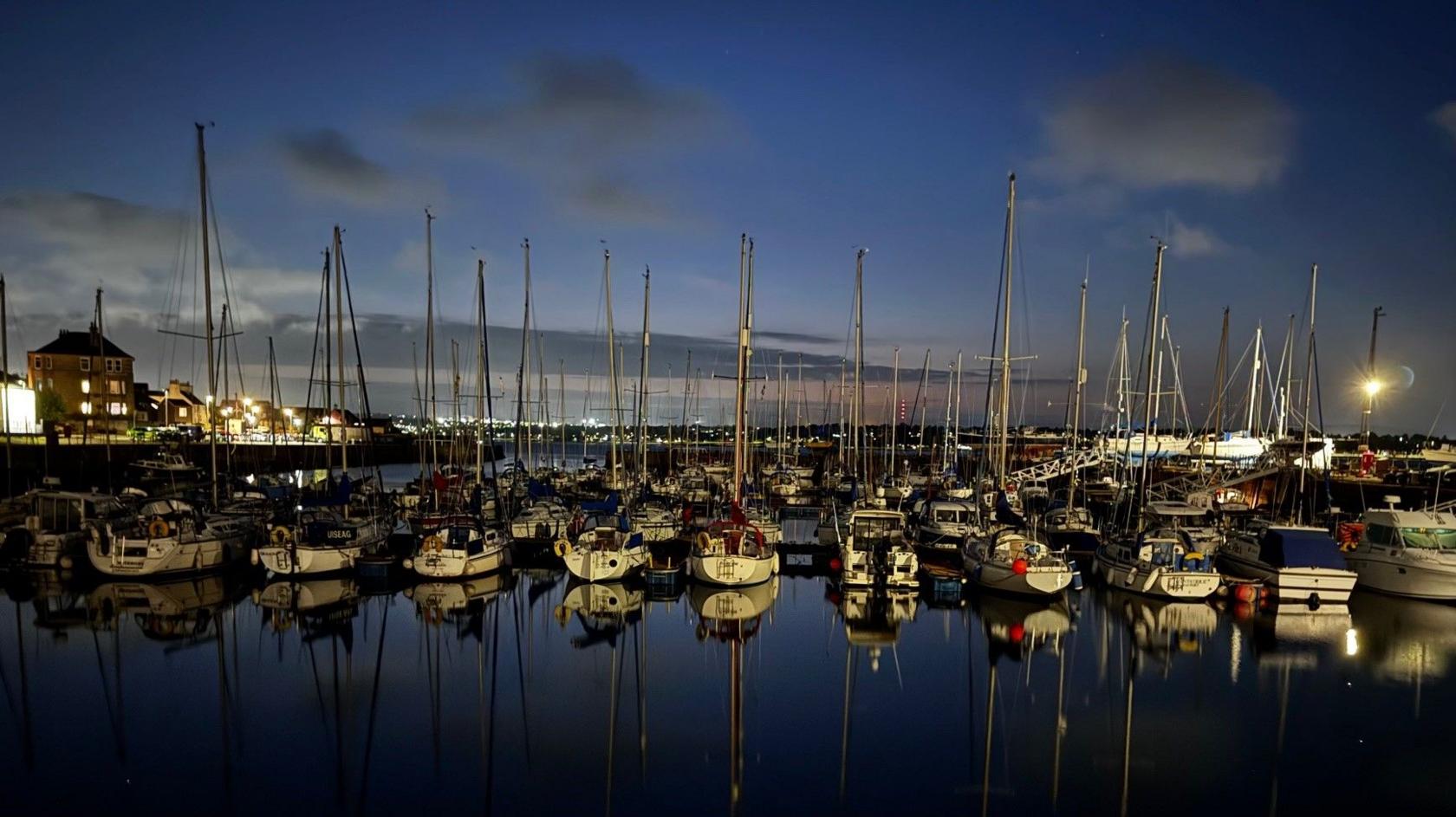 Yachts and boats in a harbour at night