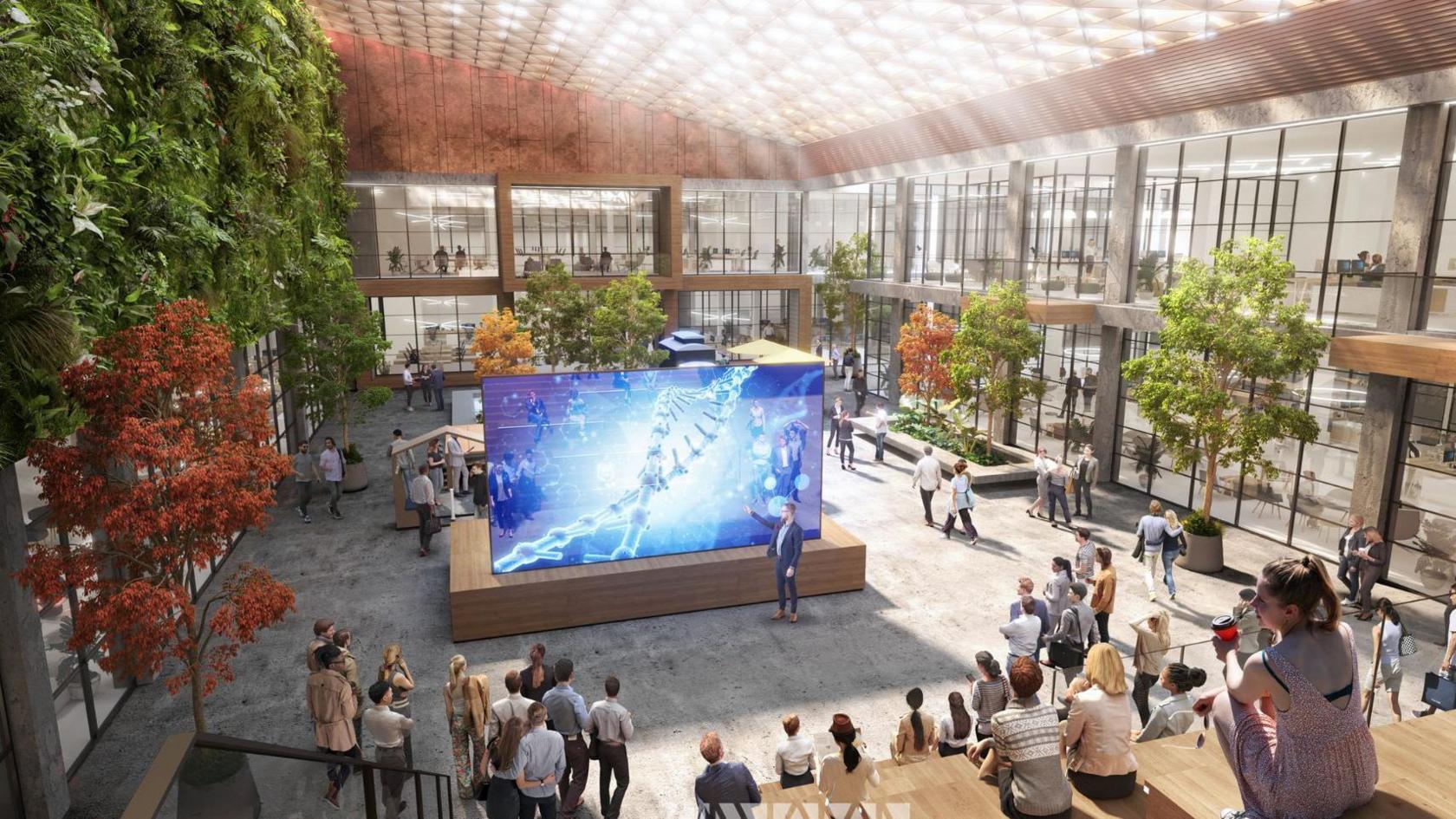 A computer generated image shows a large open indoor space with people gathered on tiered seats. A person is pointing at a big screen with a picture of a double helix on it.