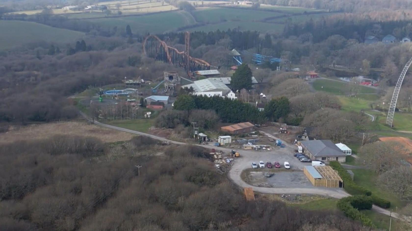 Drone image showing the theme park from above. There are trees and woodland, and fields surrounding the park.