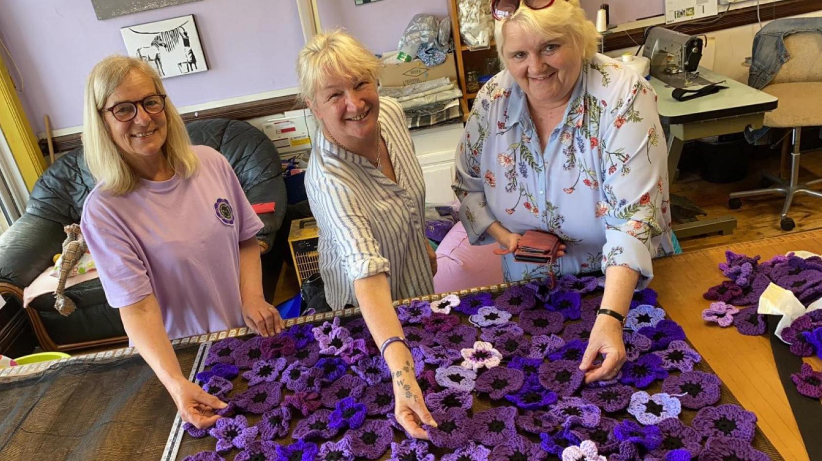 volunteers showing off their purple poppies 