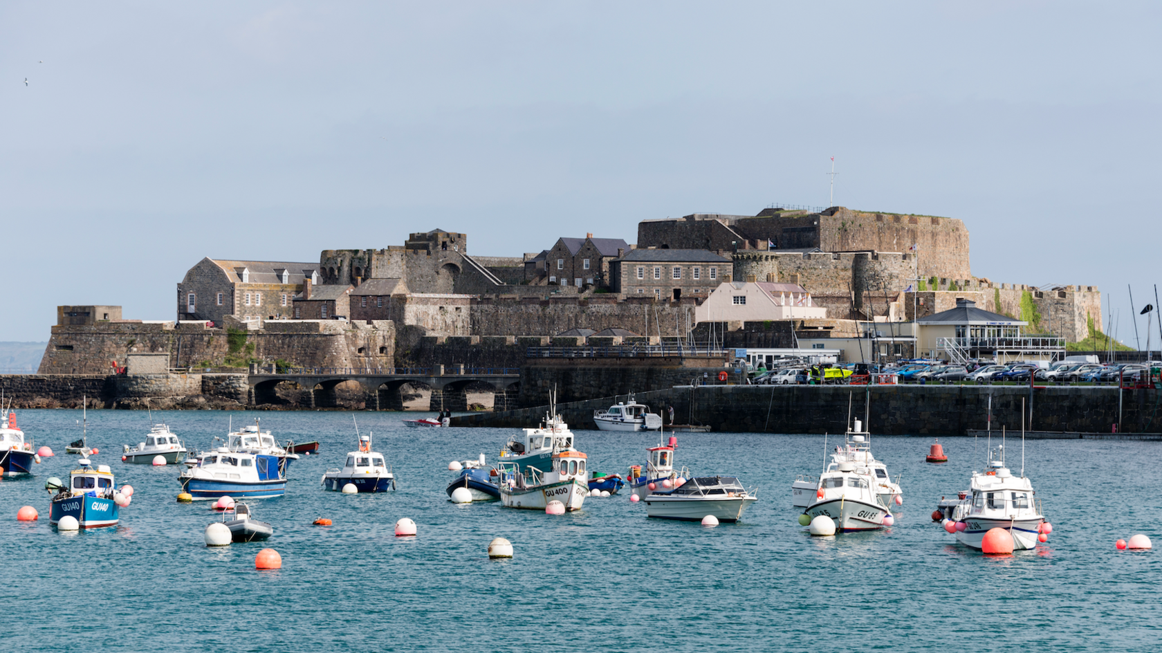 Castle Cornet is a large island castle in Guernsey, with boats in front in the sea