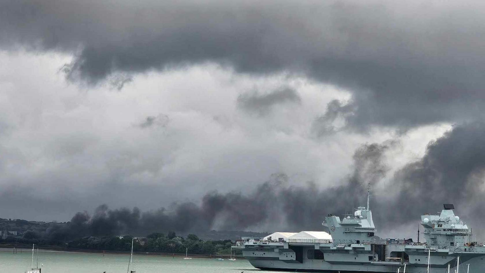 A large cloud of smoke hovering over a marina