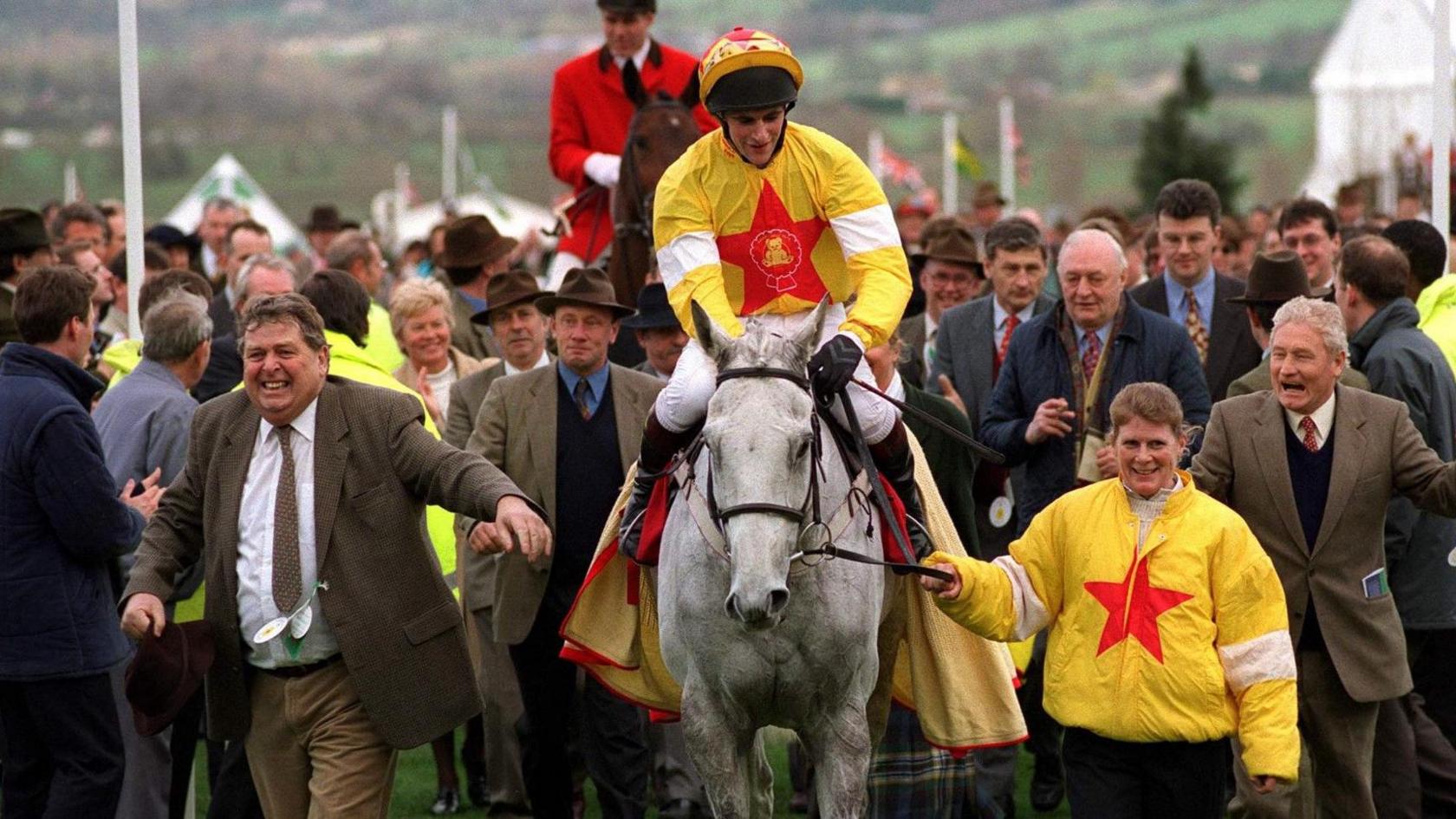 One Man and his owner John Hales entering the winners' enclosure with jockey Brian Harding and trainer Gordon Richards at Cheltenham in 1998