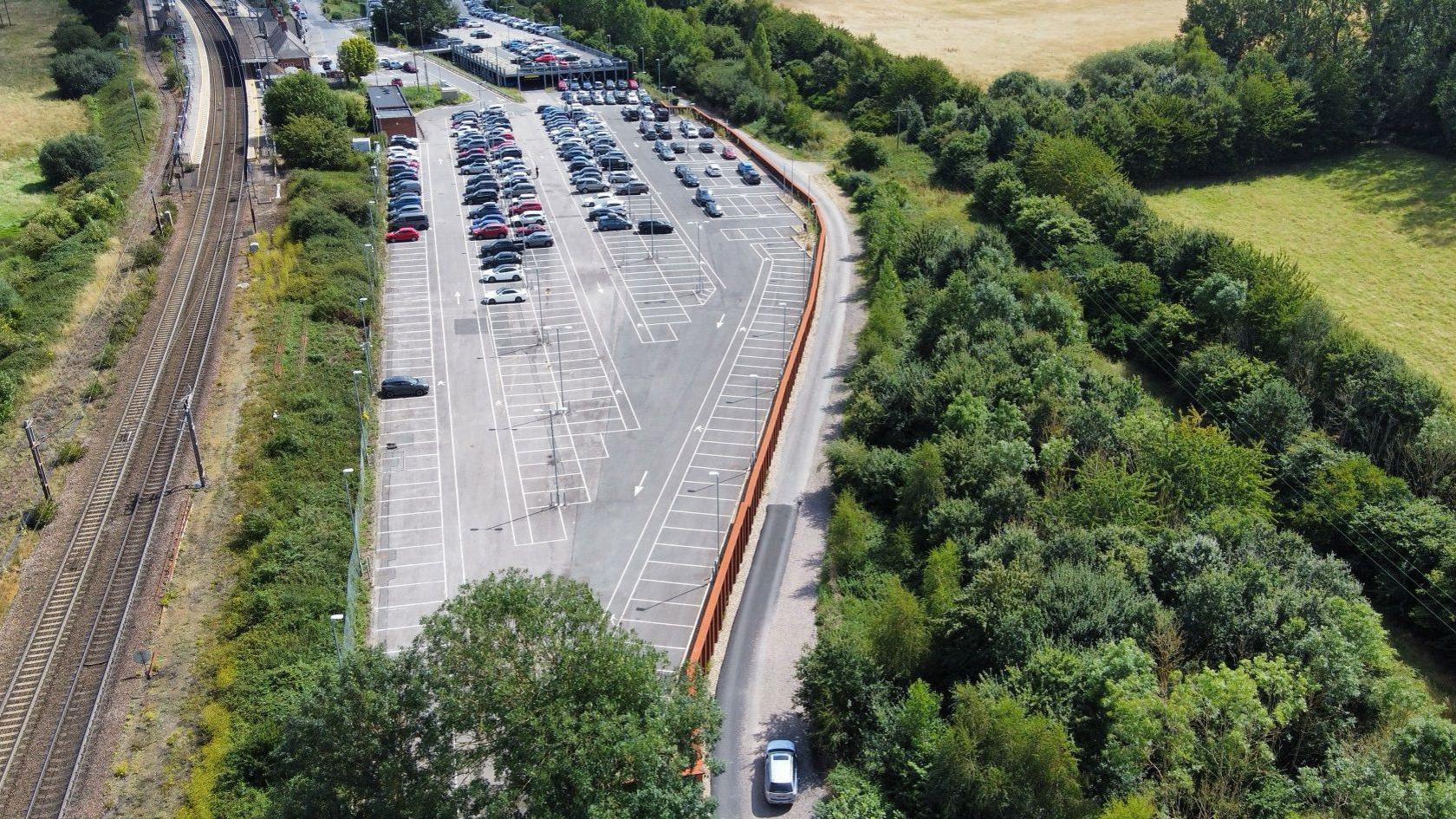 An ariel view of Manningtree Station railway and car park with countryside on the right