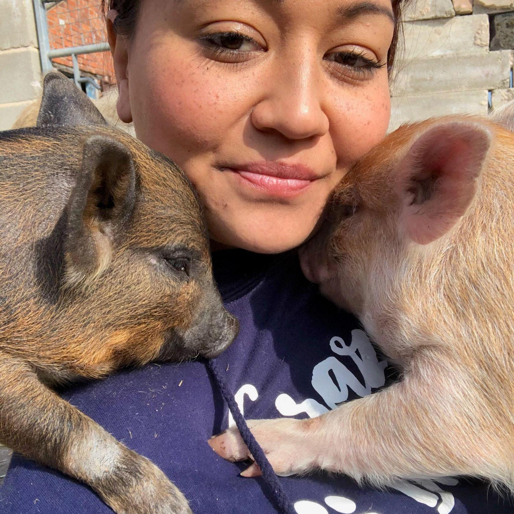 Carly Knott at home with two of her rescue pigs