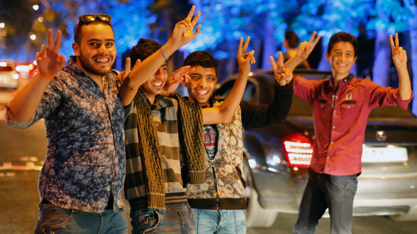 Iranians flash the victory sign as they celebrate in the streets of Tehran, Iran - 14 July 2015