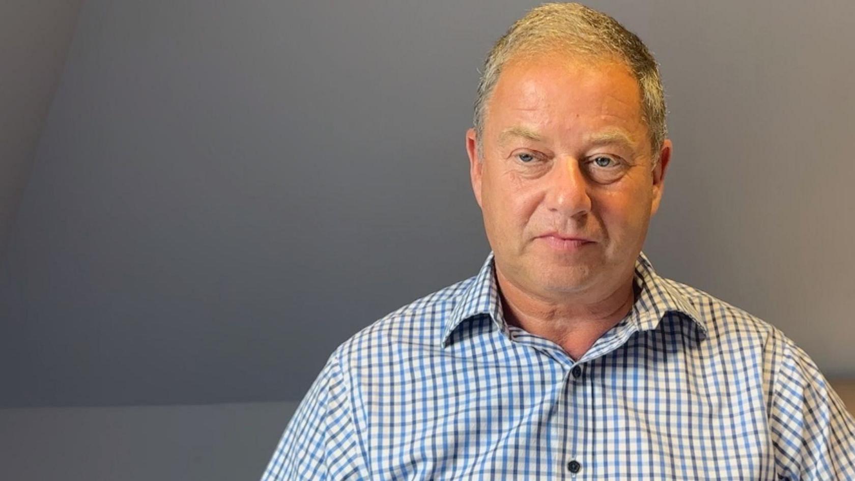 Pensions expert Mike Freer, in his office in Jersey. He is wearing a blue and grey shirt and has grey hair