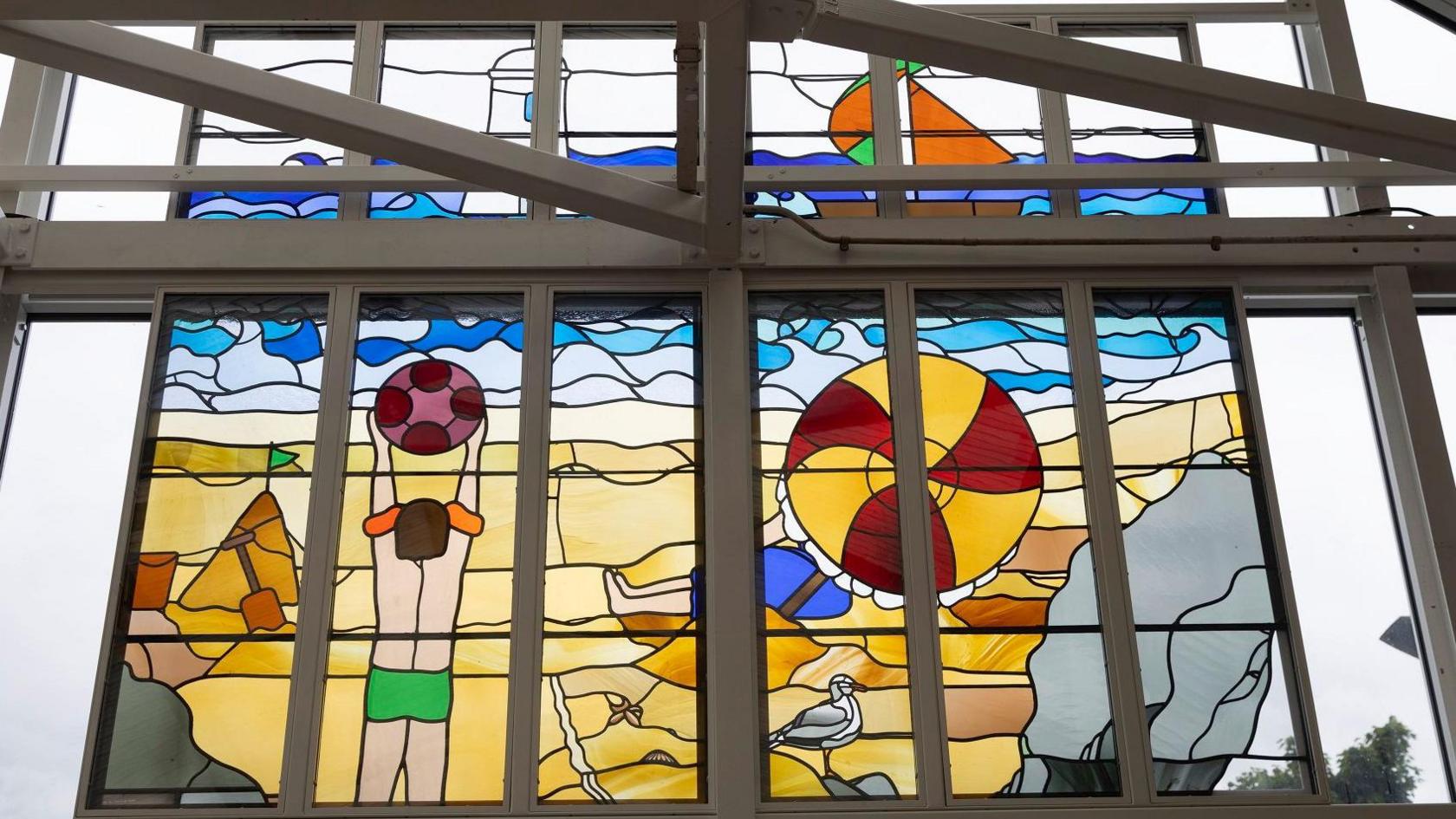 The Beach artwork depicts a person hold a football on the beach as well as golden sand