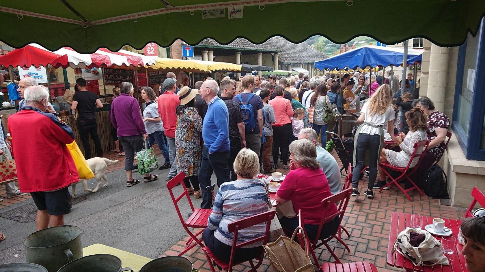 A group of people walking around a market