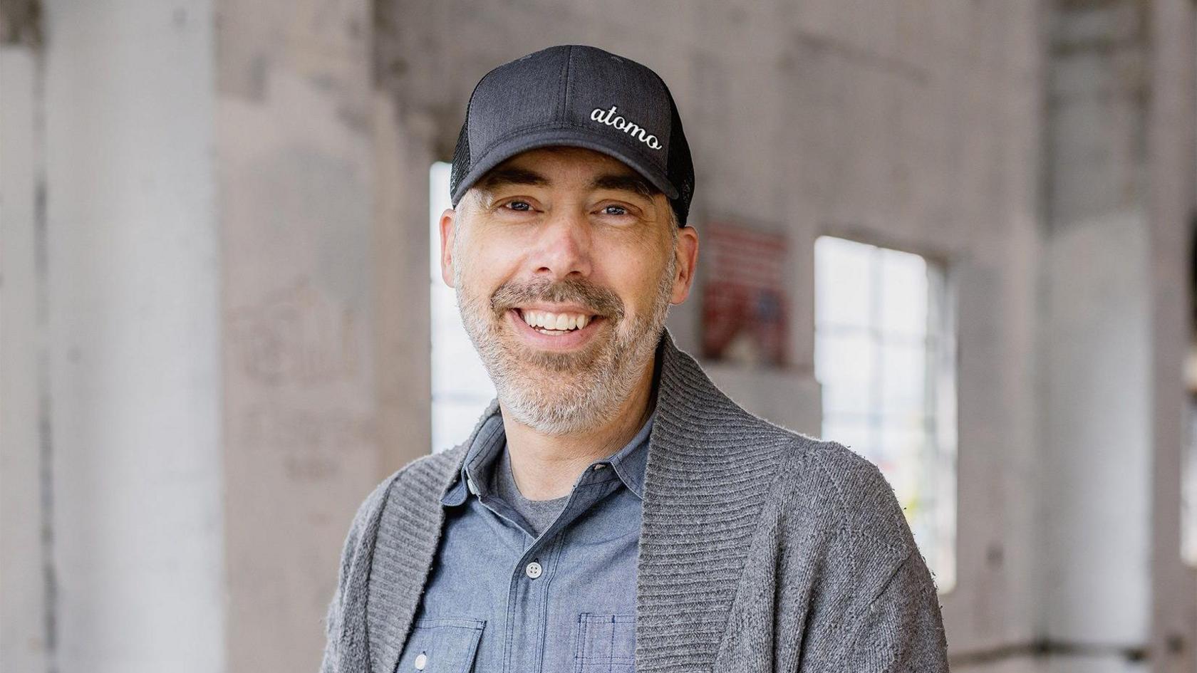 Andy Kleitsch, the chief executive of Seattle based start-up Atomo, smiling and wearing a baseball cap