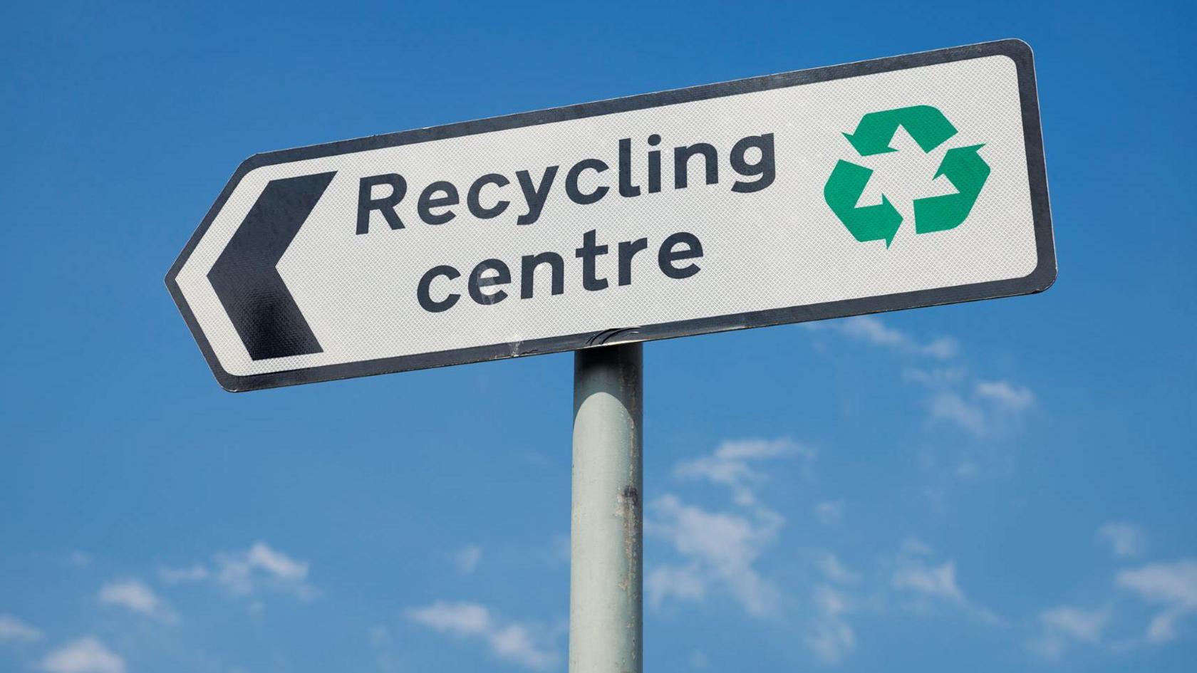 A generic photo of a recycling centre sign against a blue sky.