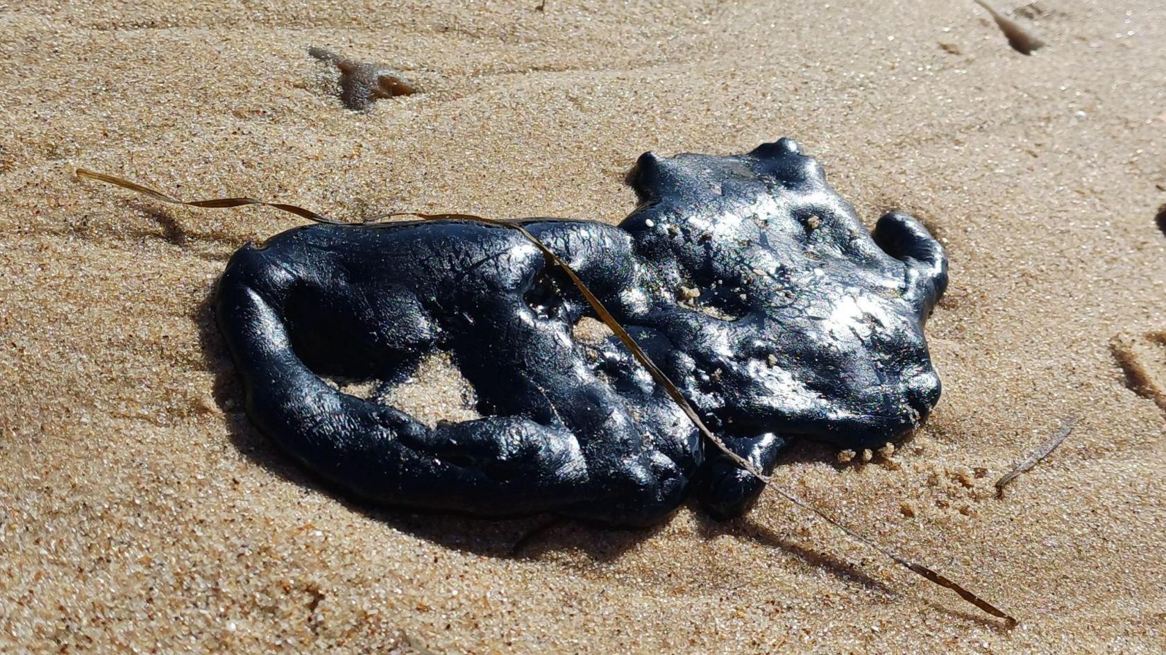 Debris from a bitumen spillage, which has washed up on the beach.