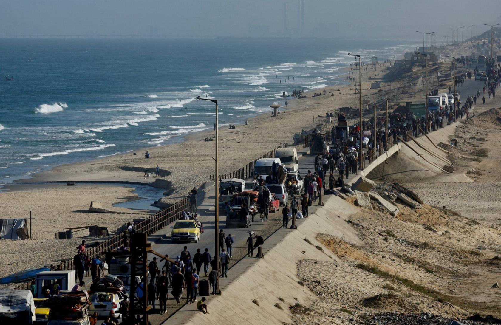Palestinians make their way along a road as they return to northern Gaza, during the ceasefire.