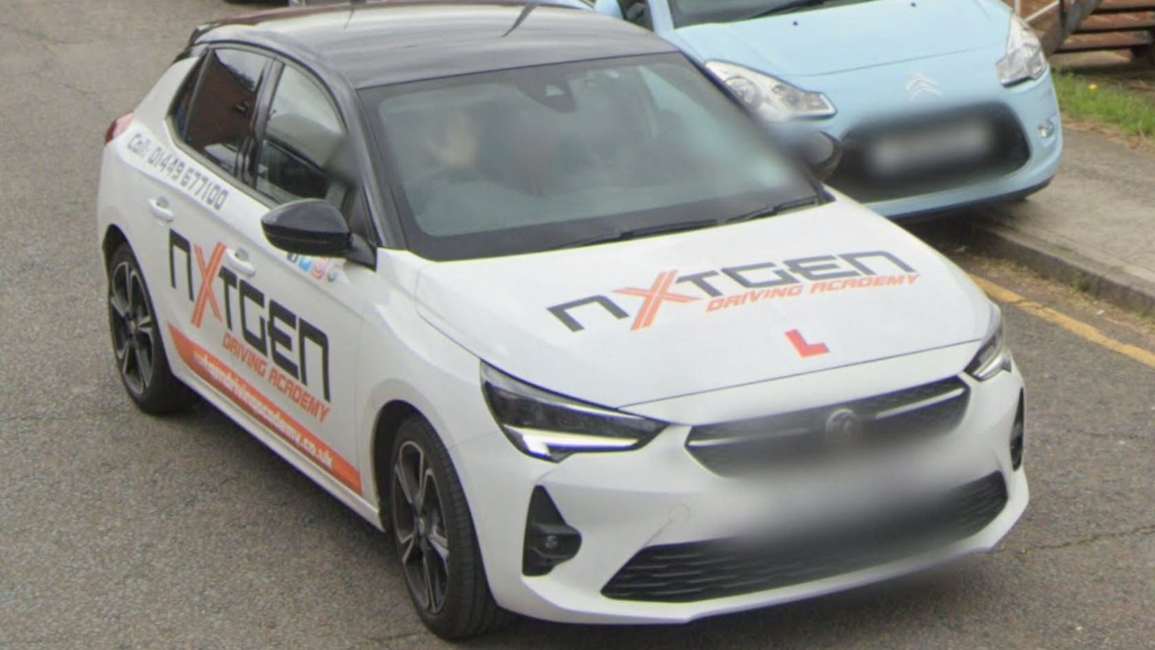 A Google Maps street view image of a white Vauxhall with the NxtGen Driving Academy branding on it.