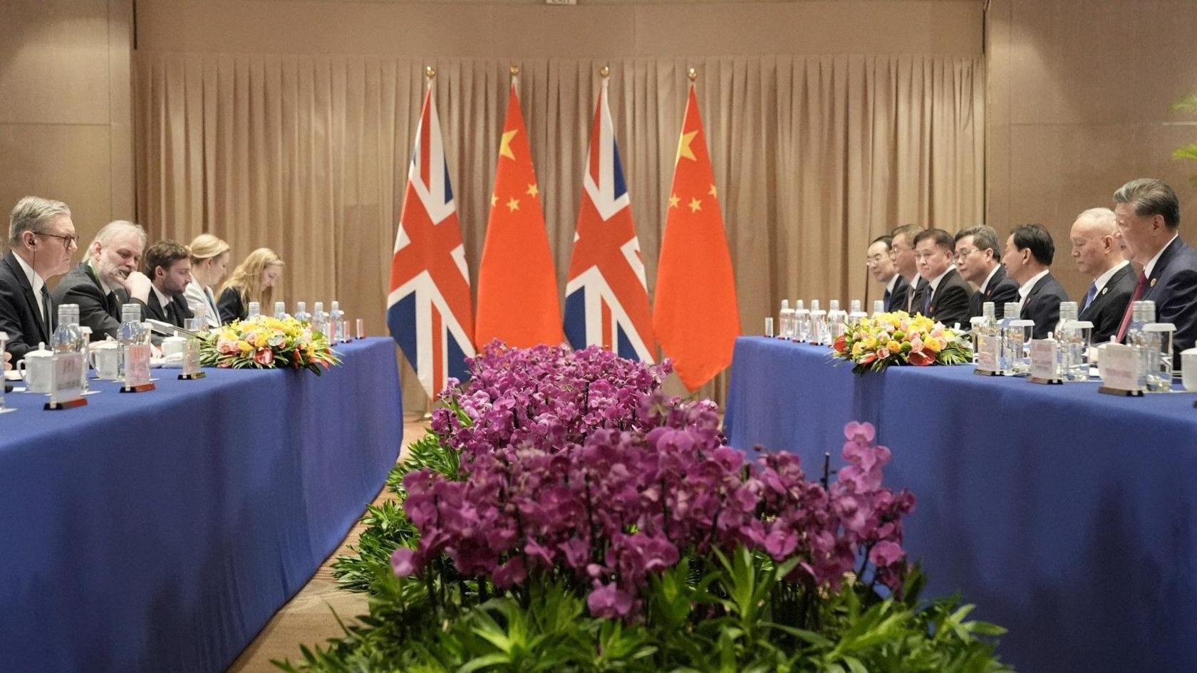 British Prime Minister Keir Starmer attends a bilateral meeting with President Xi Jinping - their teams sit opposite each other, with UK and Chinese flags between them