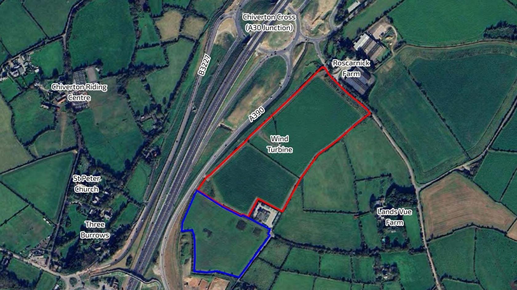 A Google Earth photo of the Chiverton Cross area which has two areas marked and overlaid, one outlined in blue and the other in red. The red shows the site's boundary and the blue shows other land also owned by the applicant, which adjoins the site boundary. There is a wind turbine marked in the red zone and two neighbouring farms to the right - Roscarnick Farm and Lands Vue Farm. To the left across the A30 Chiverton Riding Centre, St Peter Church and Three Burrows are marked.