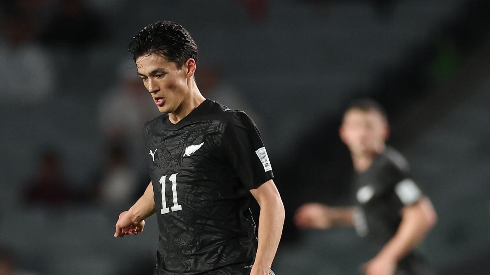 Elijah Just dribbles with the ball in an international friendly between New Zealand and Chile