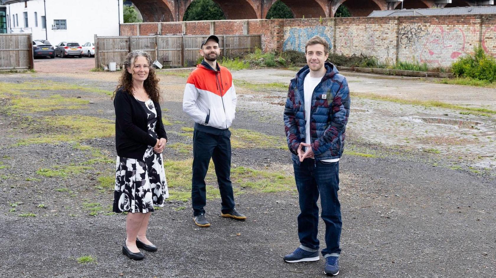 Left to right: Tracey Moore (left) from Project North East, Carlo Viglianisi of Building Culture and Mark Shields at the Woods Pottery site. Brick walls and a wooden fence in the background