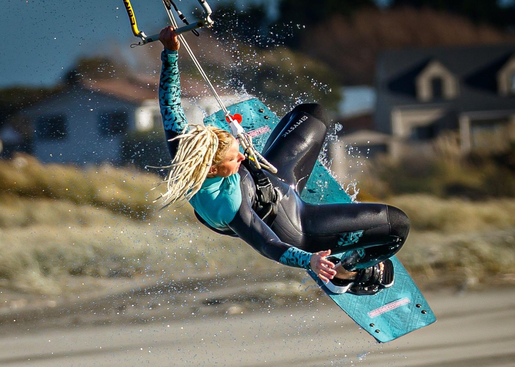 A woman kite surfer lifts off