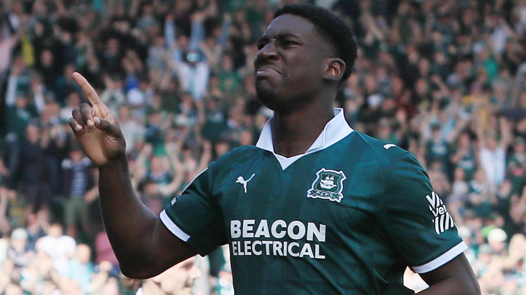 Bim Pepple wearing a green and white Plymouth Argyle shirt, is in action for the club.