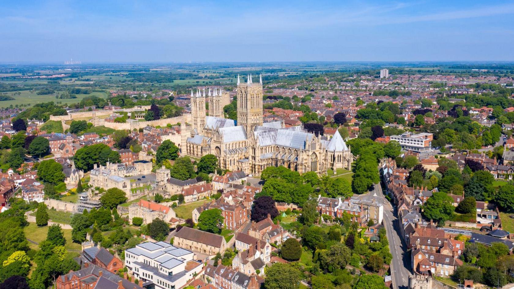 An aerial view of Lincoln Cathedral, which is surrounded by red-brick buildings and greenery