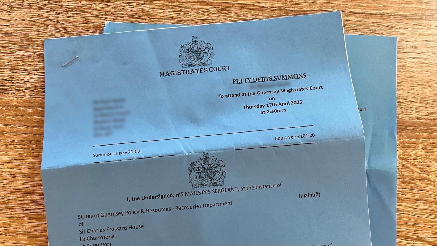 A dark blue petty debts summons from Guernsey's Royal Court. Text reads: 

MAGISTRATES COURT 

PETTY DEBTS SUMMONS
To attend at the Guernsey Magistrates Court on Thursday 17th April 2025 at 2:30p.m.
Summons Fee £76.00
Court Fee £161.00

I, the Undersigned, HIS MAJESTY'S SERGEANT, at the Instance of States of Guernsey Policy & Resources - Recoveries Department of Sir Charles Frossard House.