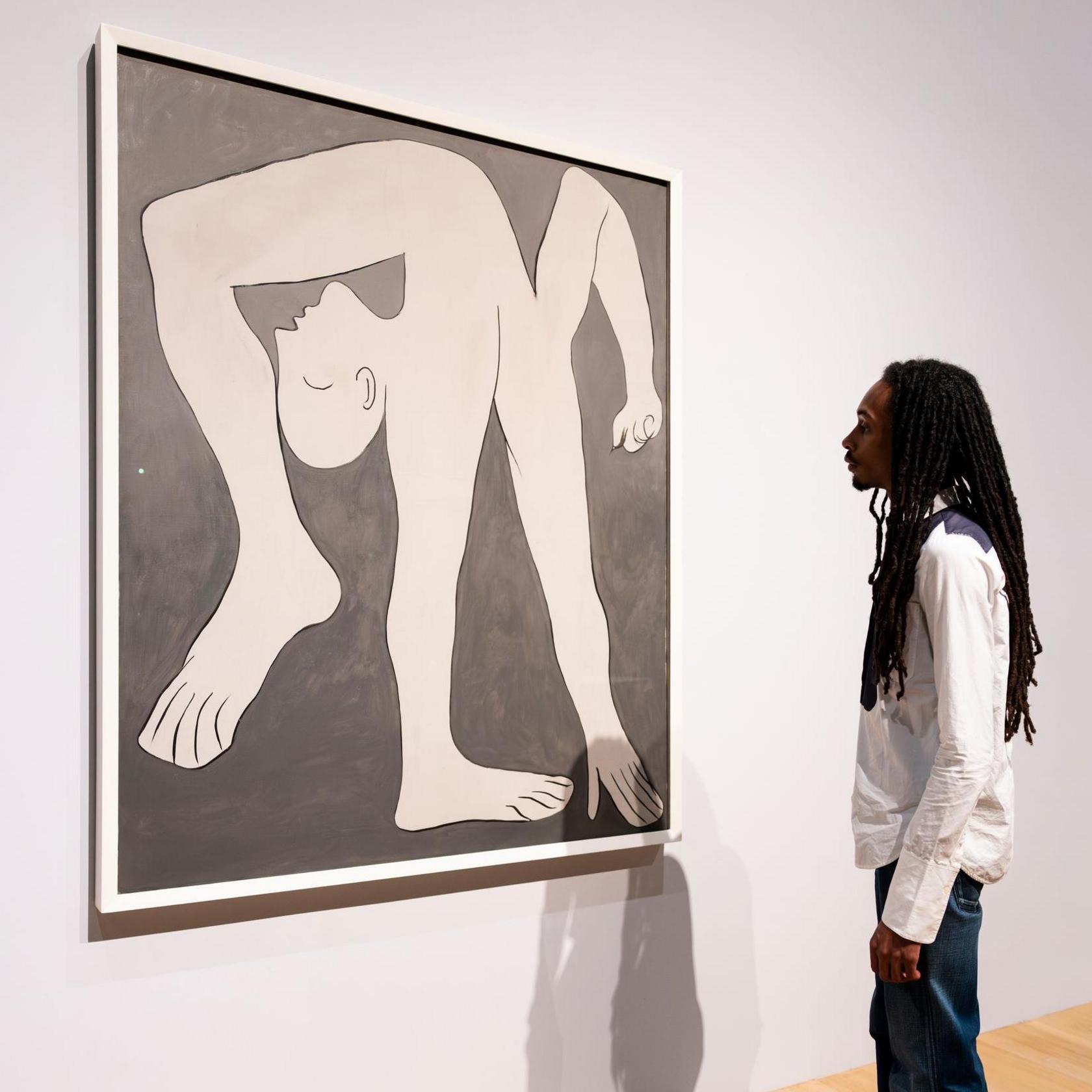 A person stands in front of an artwork. The picture is a simple black and white sketch of an acrobat bending over backwards in a seemingly impossible pose.