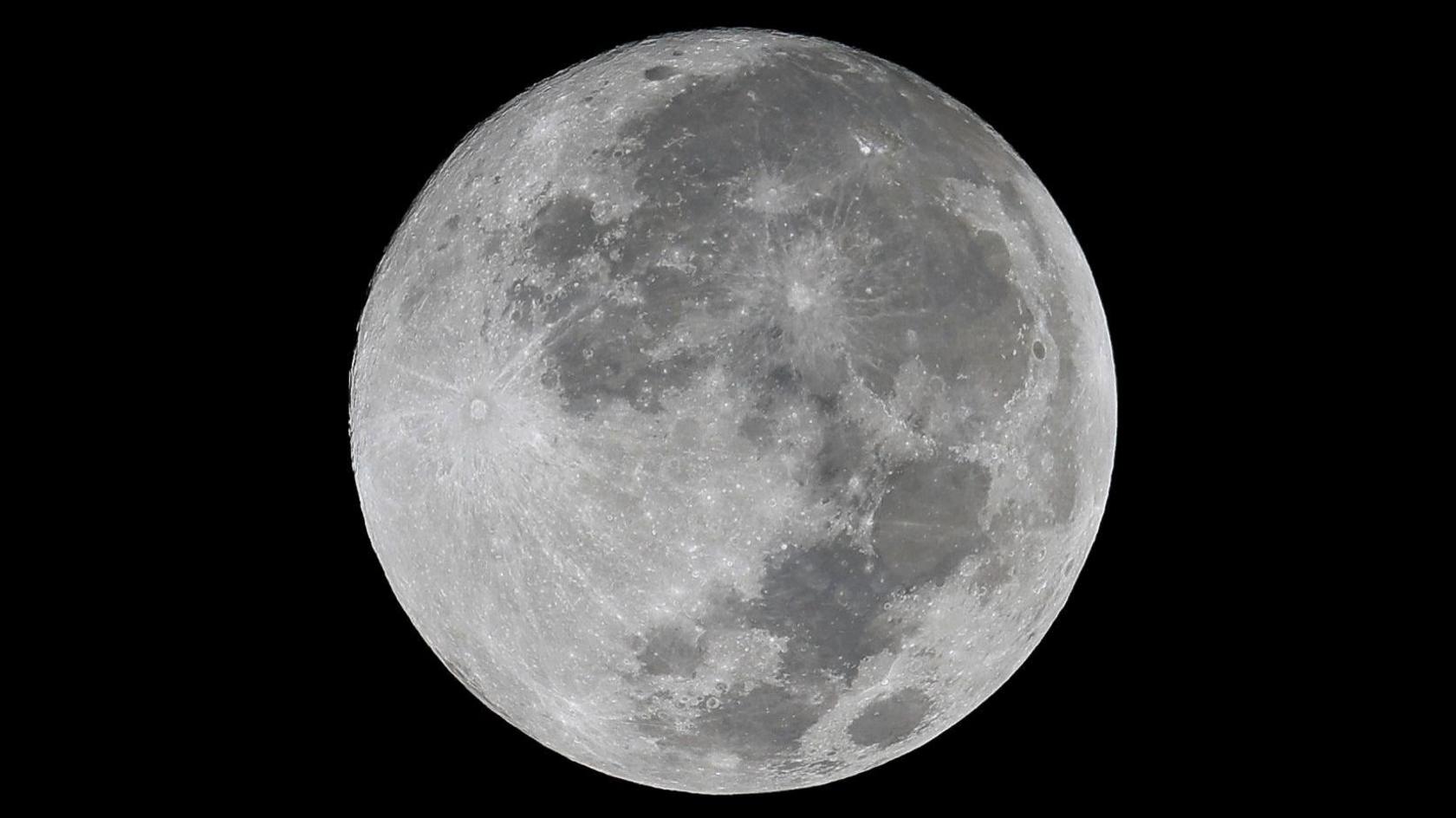 A close up picture of a full moon on a black night sky