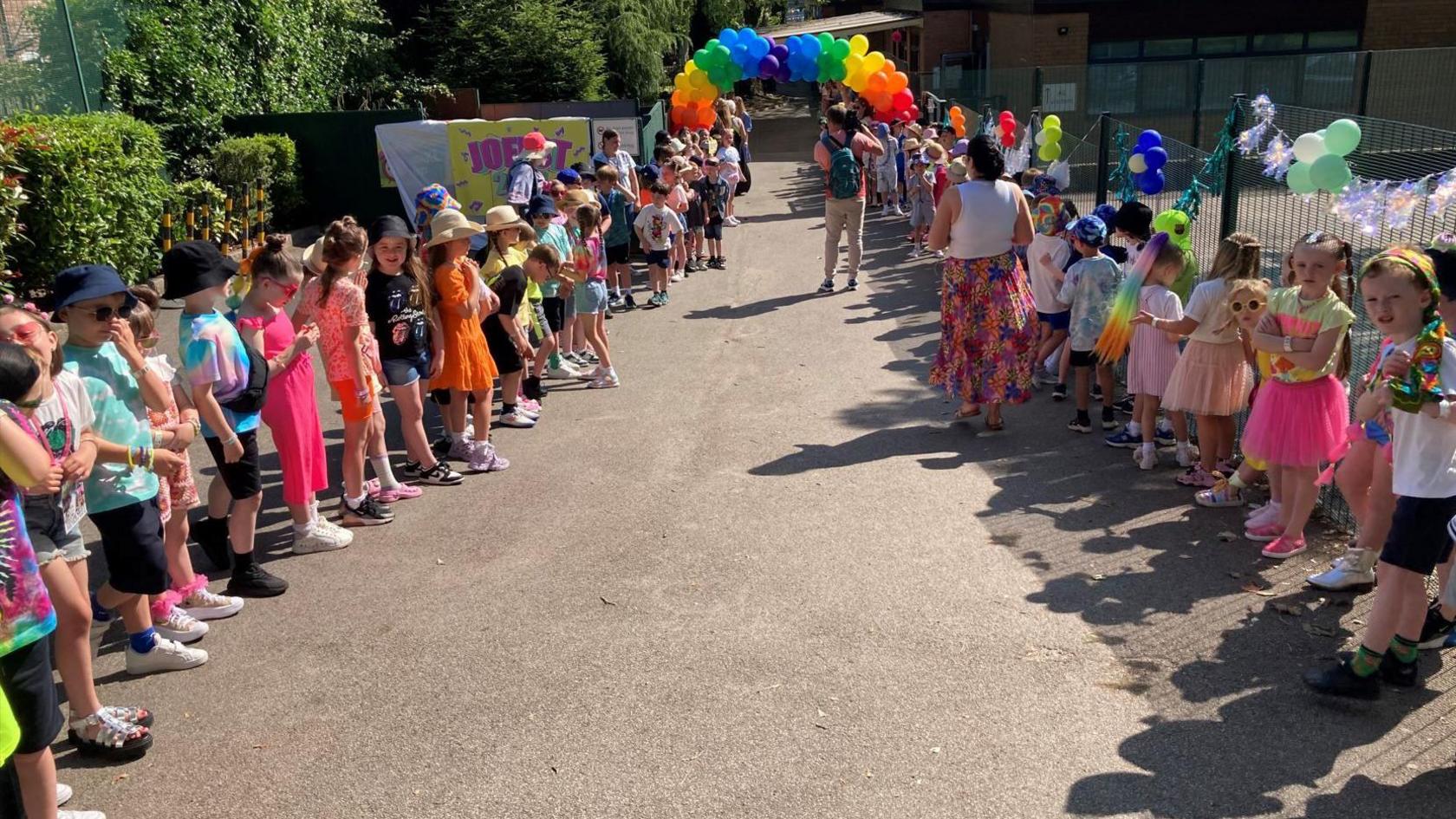 Children lined up in playground to welcome headteacher