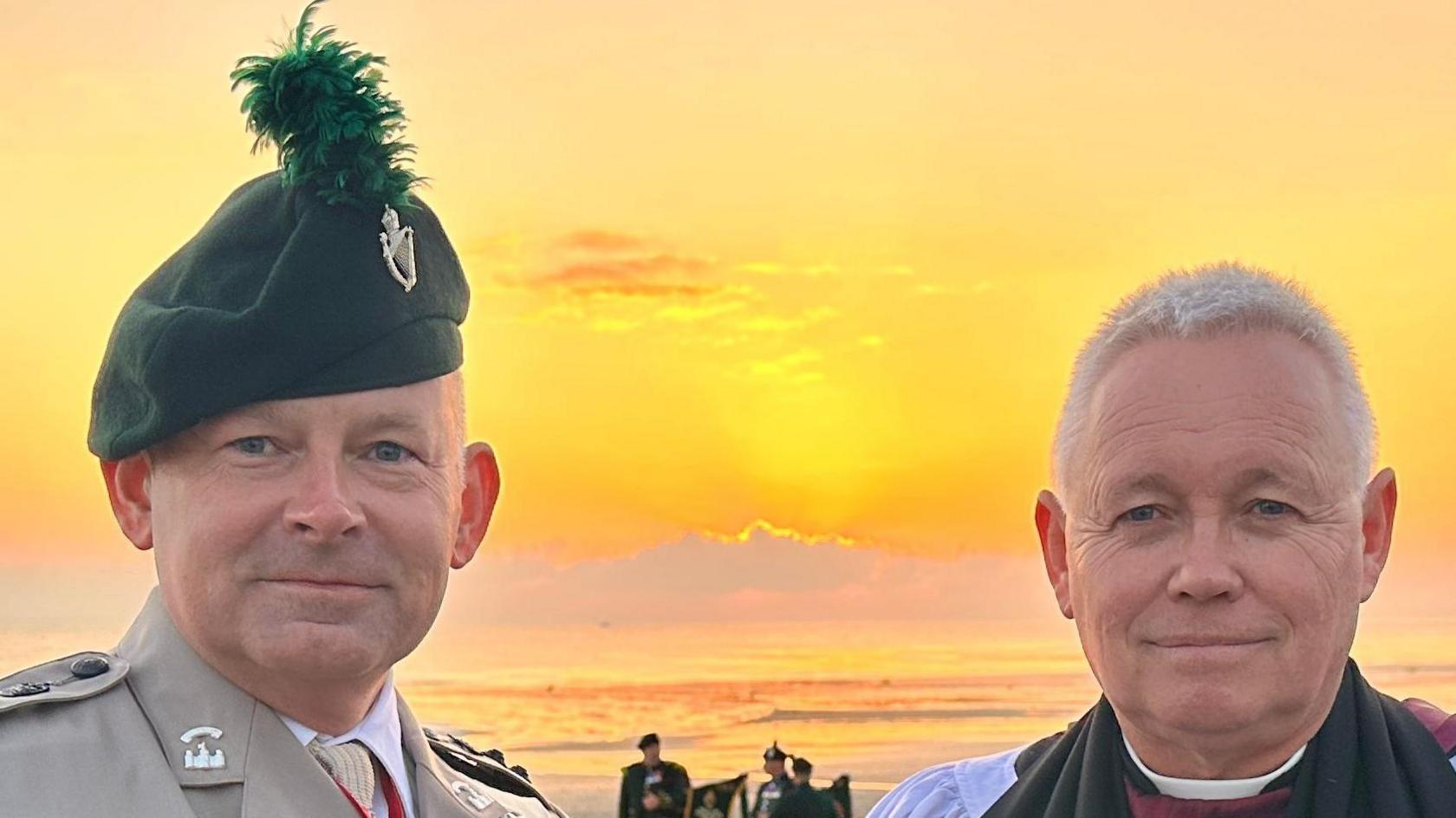 A chaplain and a soldier on a beach in Normandy