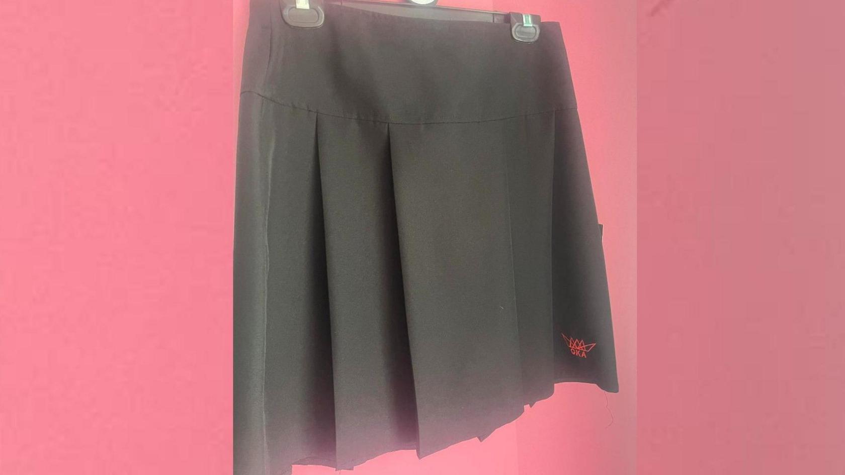 Grey skirt with a red school logo 