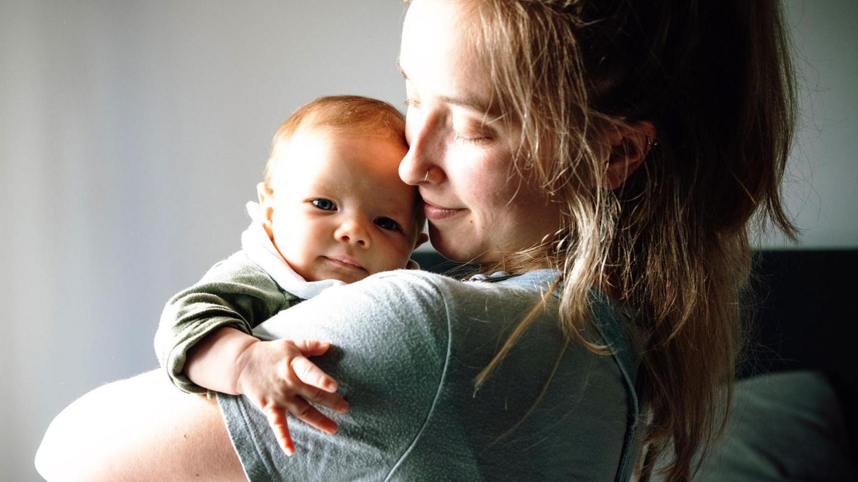A young mother holding a baby