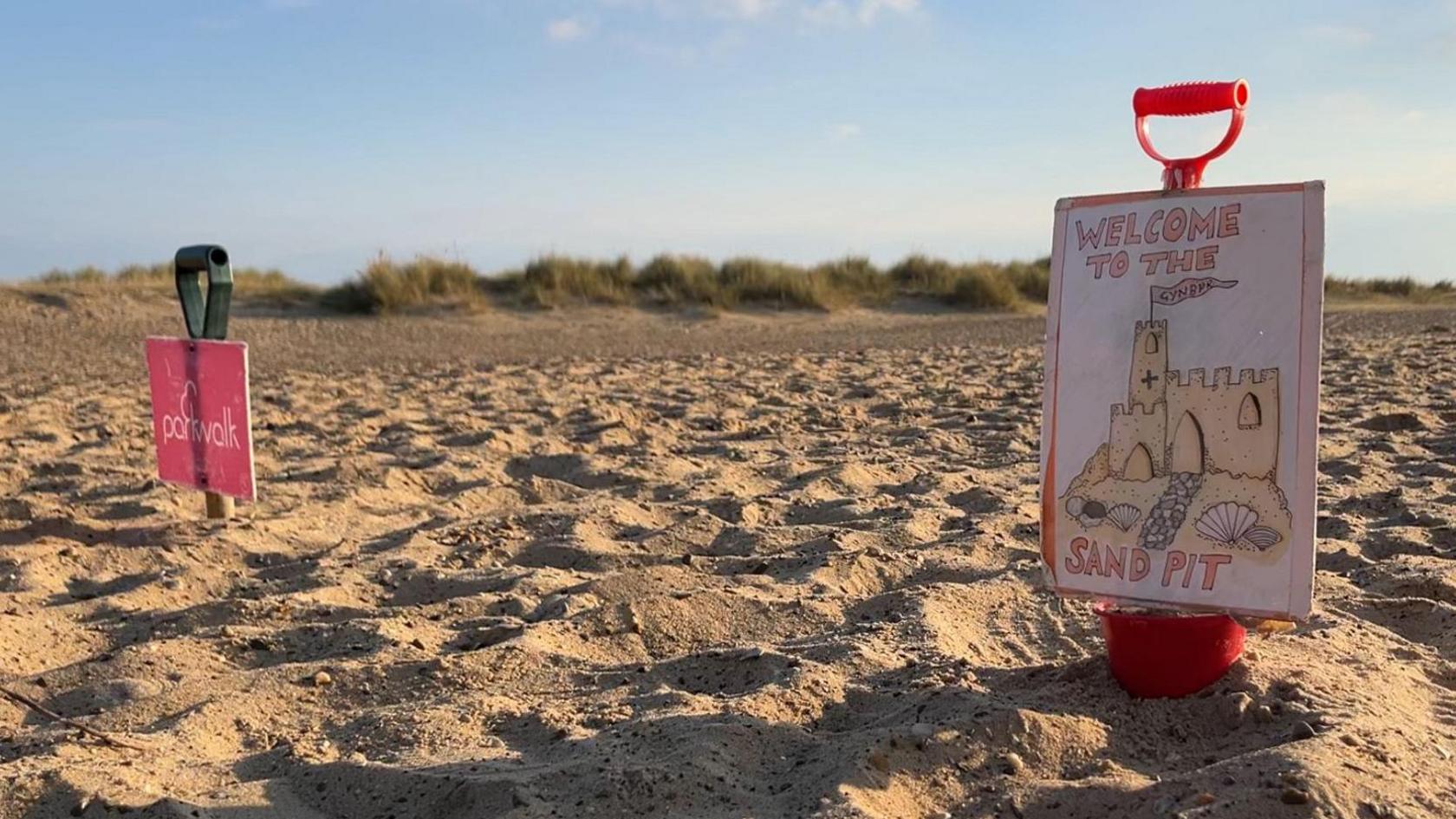 Parkrun signs in the sand.